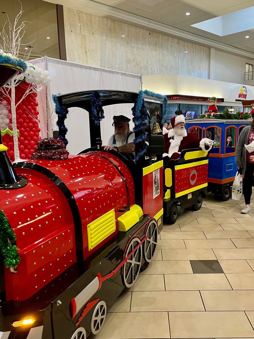 Santa Claus arriving on the All Smiles Aboard trackless train at the mall