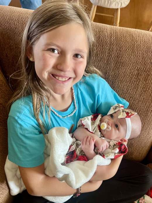 Emma smiling while holding a baby
